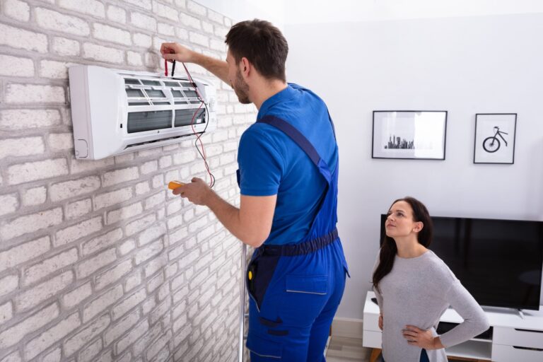Technician Repairing Air Conditioner With Digital Multimeter